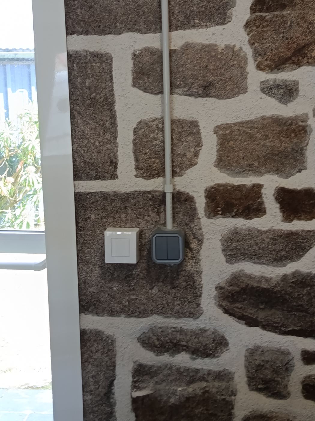 Finition interrupteur sur mur en pierre